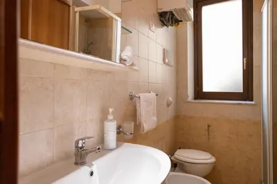 a bathroom with a sink and a toilet and a window at Hola Cathedral House Cadorna in Palermo
