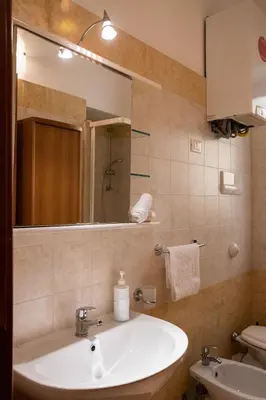 a bathroom with a sink and a mirror and a toilet at Hola Cathedral House Cadorna in Palermo