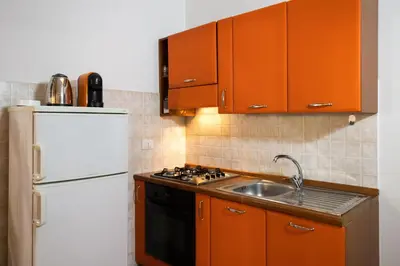 a kitchen with a white refrigerator and a sink at Hola Cathedral House Cadorna in Palermo