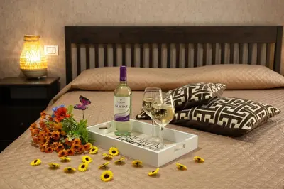 a bottle of wine and a tray with flowers on a bed at Sunset House in Balestrate