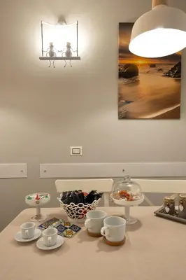 a table with cups and bowls on top of it at Sunset House in Balestrate