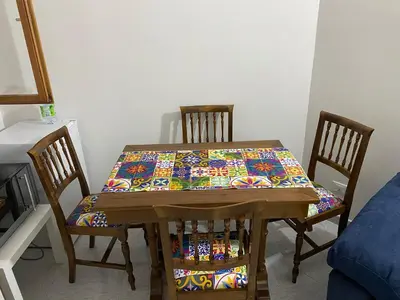 a dining room table with two chairs with a colorful cloth on it at Casa Luminaria in Palermo