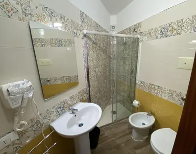 a bathroom with a sink and a shower and a toilet at Casa Luminaria in Palermo