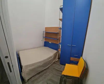 a small room with a small bed and a blue door at Casa mulini in Palermo