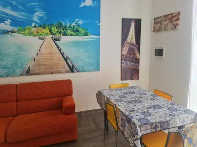 a dining room with a table and a picture of a pier at Casa mulini in Palermo