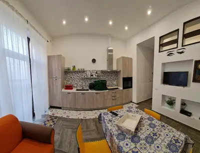 a living room with a table and a kitchen at Casa mulini in Palermo