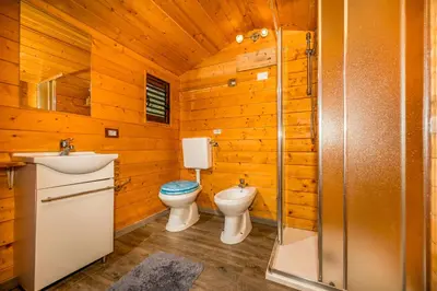 a bathroom with two toilets and a sink and a shower at Palma Dello Zingaro in Scopello