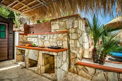an outdoor kitchen with a stone wall at Palma Dello Zingaro in Scopello