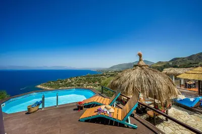 a resort with a swimming pool and a view of the ocean at Palma Dello Zingaro in Scopello