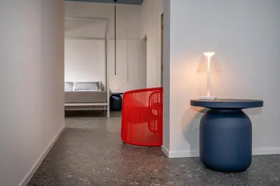 a bedroom with a bed and a blue chair at BED 10.5 - DESIGN SUITE in Castellammare del Golfo