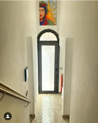 a door to a building with a tree in a vase at Atelier House 69 in Trappeto
