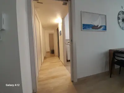 a hallway leading to a room with white walls and wood floors at Les Voiles in Terrasini