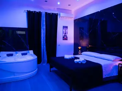 a bedroom with a tub and a bed and a sink at Aliva suite LT in Palermo