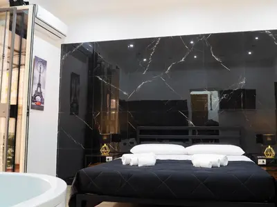 a black and white bedroom with a bed and a tub at Aliva suite LT in Palermo