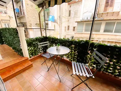 a patio with a table and chairs on a balcony at Aliva suite LT in Palermo