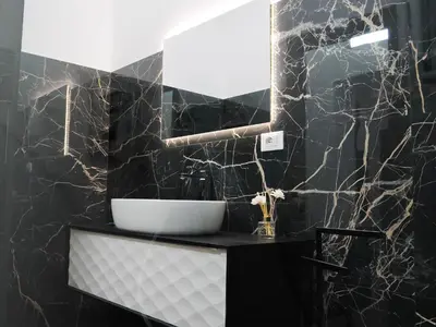 a black bathroom with a sink and a mirror at Aliva suite LT in Palermo