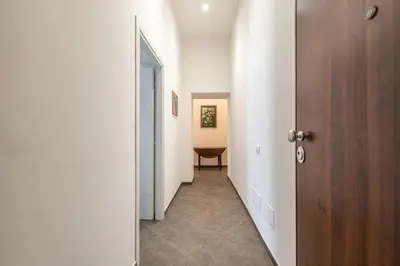a hallway with white walls and a wooden door at Apartments La Cala by Wonderful Italy in Palermo