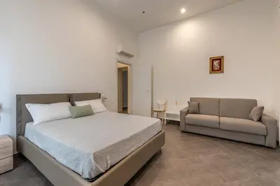 a bedroom with a bed and a couch at Apartments La Cala by Wonderful Italy in Palermo