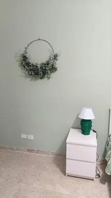 a wreath on a wall with a lamp on a dresser at I mori e le dame - Fast Fiber Wi-Fi, Central Palermo in Palermo