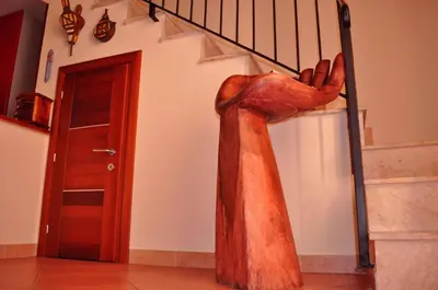 a statue of a hand on a stair case at Kalza House in Palermo