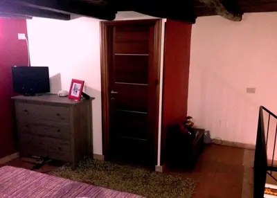 a bedroom with a wooden door and a dresser at Kalza House in Palermo