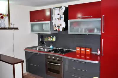 a kitchen with red cabinets and a stove top oven at Kalza House in Palermo