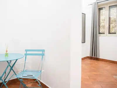 a blue chair sitting next to a table in a room at Aliva room LT in Palermo