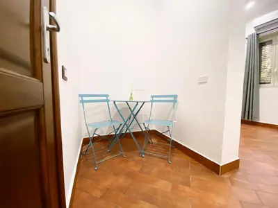 a table with two blue chairs in a room at Aliva room LT in Palermo
