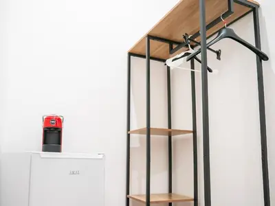 a glass shelf with a red bottle on it next to a refrigerator at Aliva room LT in Palermo