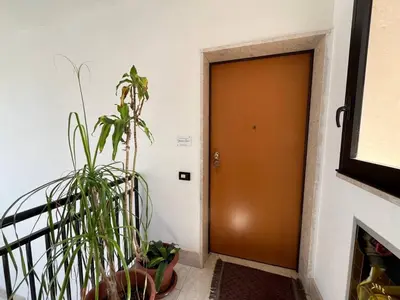 a hallway with a door and a potted plant at Appartamento Gemma D'oro in Castellammare del Golfo