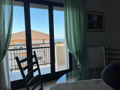 a room with a glass table and a view of a balcony at Appartamento Gemma D'oro in Castellammare del Golfo