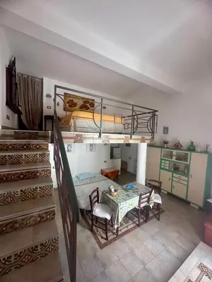 a room with a bed and a table and stairs at Le_case_di_Antonella - your holiday in Sicilia in Castellammare del Golfo