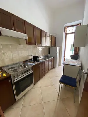 a kitchen with wooden cabinets and a stove top oven at Le_case_di_Antonella - your holiday in Sicilia in Castellammare del Golfo
