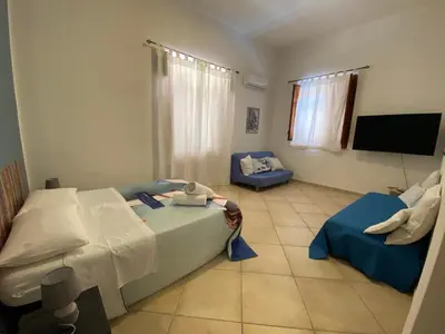 a bedroom with two beds and a flat screen tv at Le_case_di_Antonella - your holiday in Sicilia in Castellammare del Golfo