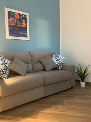 a couch in a living room with a blue wall at Cortile dei Mori in Palermo