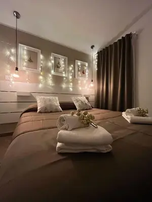 a bedroom with two beds with towels and lights at Cortile dei Mori in Palermo