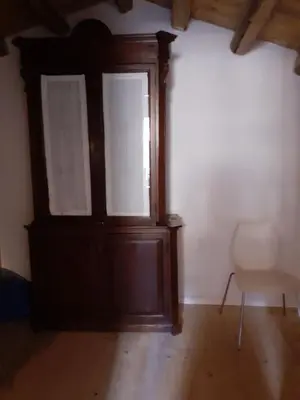 a room with a wooden door and a chair at Domus 31 in Palermo