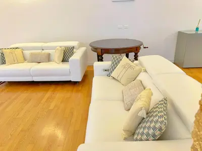 a living room with two white couches and a table at Giardino Segreto Luxury Home in Palermo