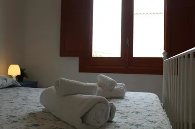 a bedroom with towels on a bed with a window at Villa Fede & Niki in San Vito lo Capo