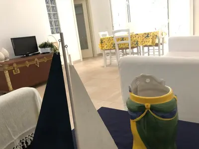 a living room with a table and a television at Villa Fede & Niki in San Vito lo Capo