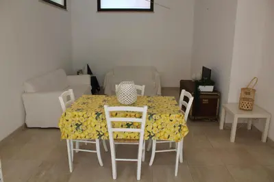 a room with a table with chairs and a couch at Villa Fede & Niki in San Vito lo Capo