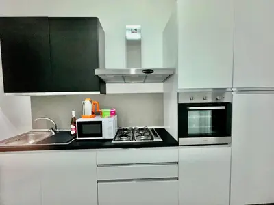 a kitchen with white cabinets and a microwave at OUR BEAUTIFUL SICILY in Palermo