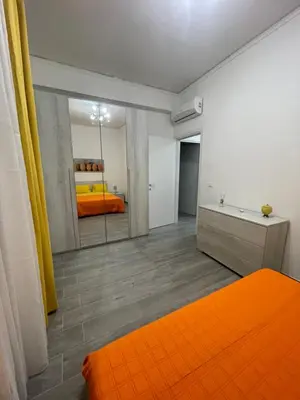 a bedroom with an orange bed and a mirror at OUR BEAUTIFUL SICILY in Palermo