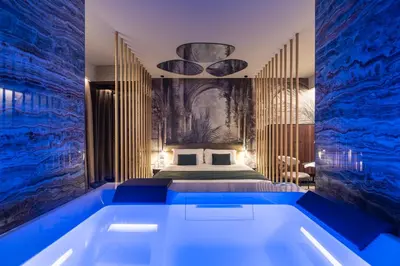 a bedroom with a large tub in front of a bed at Aquasuite - Luxury Experience & Spa in Palermo