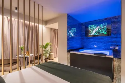 a bedroom with a tub with a tv on the wall at Aquasuite - Luxury Experience & Spa in Palermo
