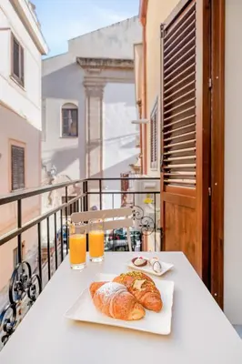 a table with two croissants and two glasses of orange juice at Aquasuite - Luxury Experience & Spa in Palermo