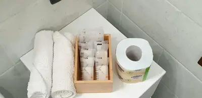 a shelf with towels and a roll of toilet paper at I Vicini del Re Holiday Home in Palermo