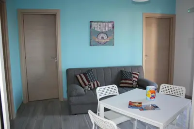 a living room with a couch and a table and chairs at Case Playa in Balestrate