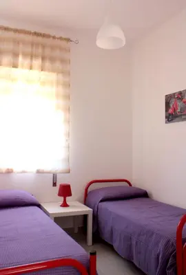 a bedroom with two beds and a window at Case Playa in Balestrate