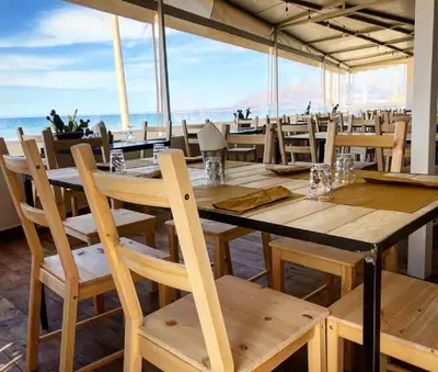 a dining room with a table and chairs and the ocean at Case Playa in Balestrate